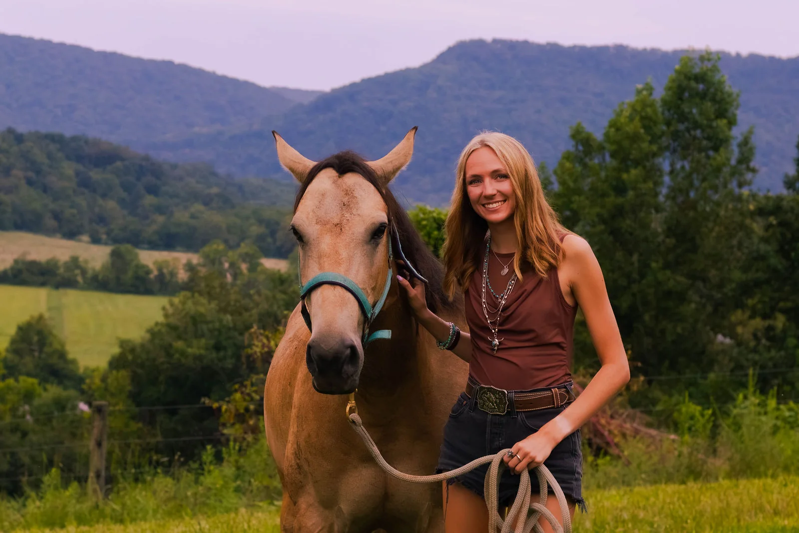 A portrait with a horse in a River Creek Stables pasture, with mountain ridges beyond